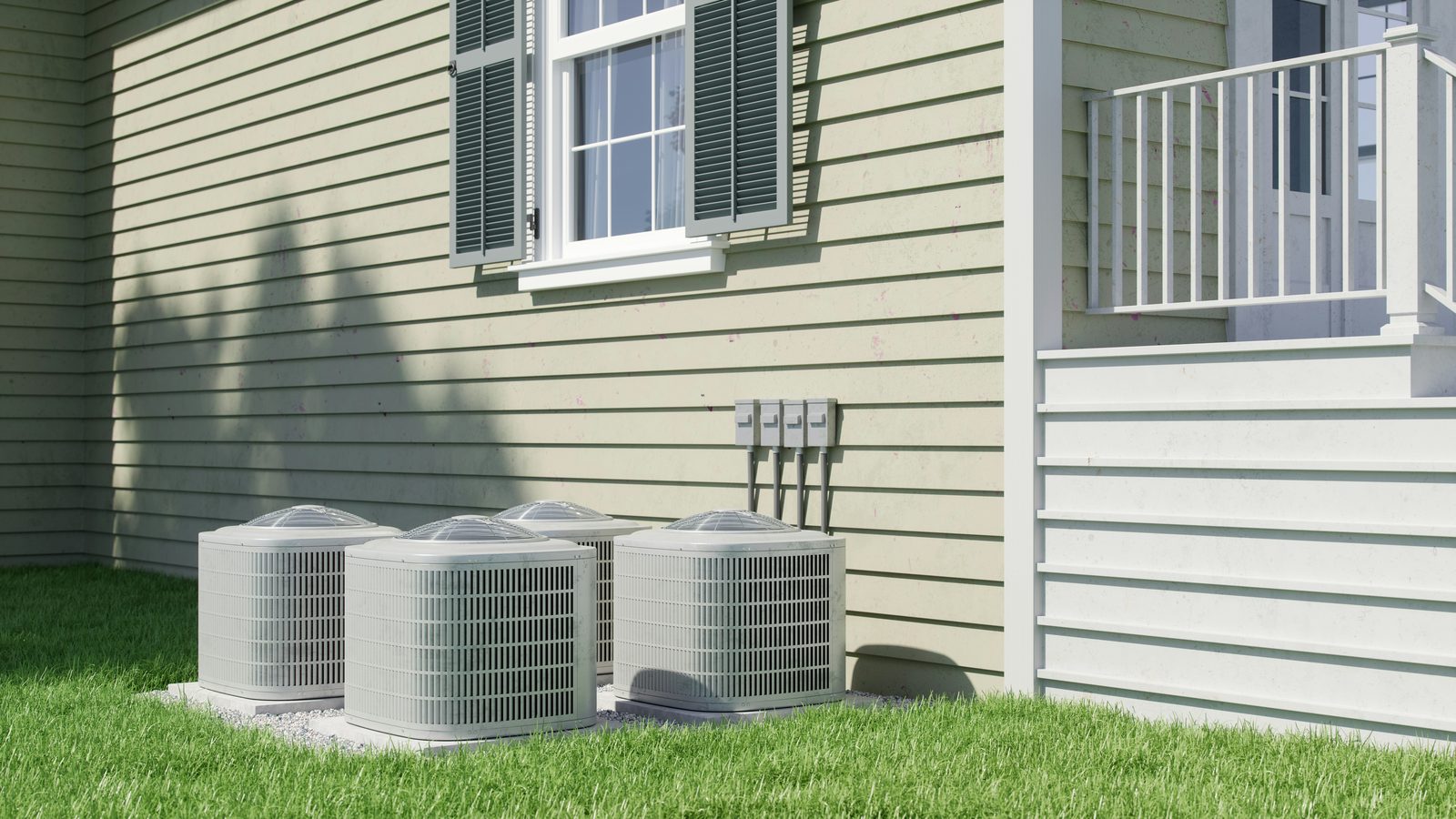 Air conditioner condenser units installed beside a home exterior on a sunny day