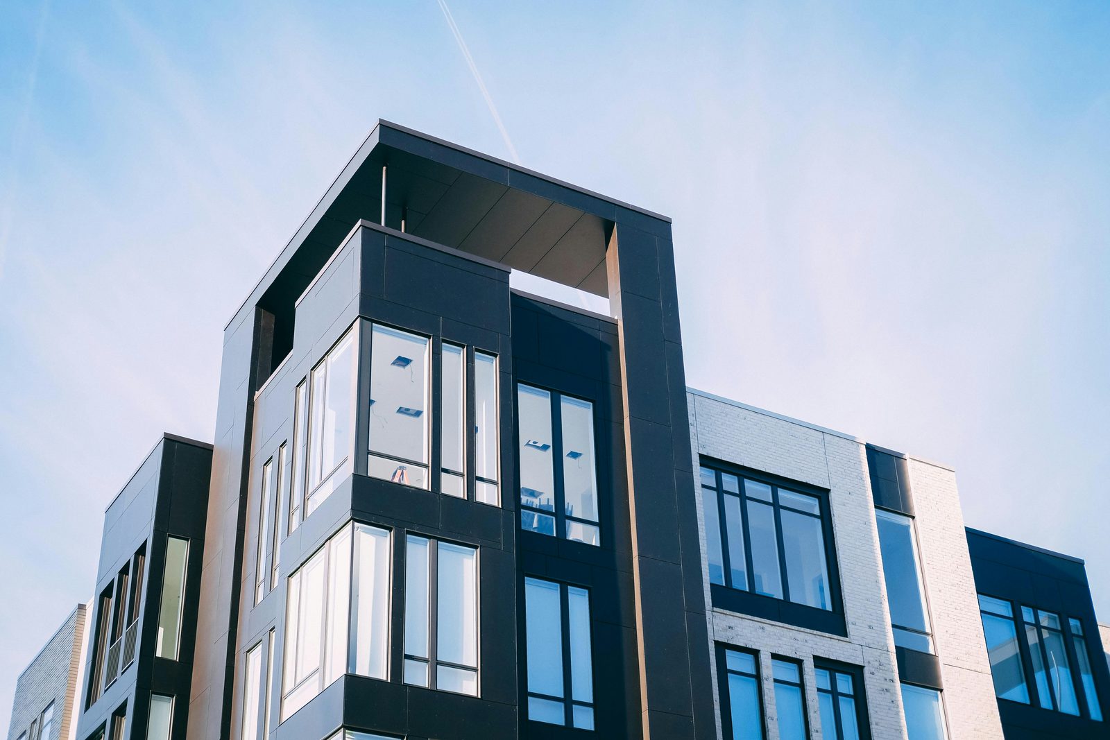 Modern multi-unit apartment and strata building against a blue sky
