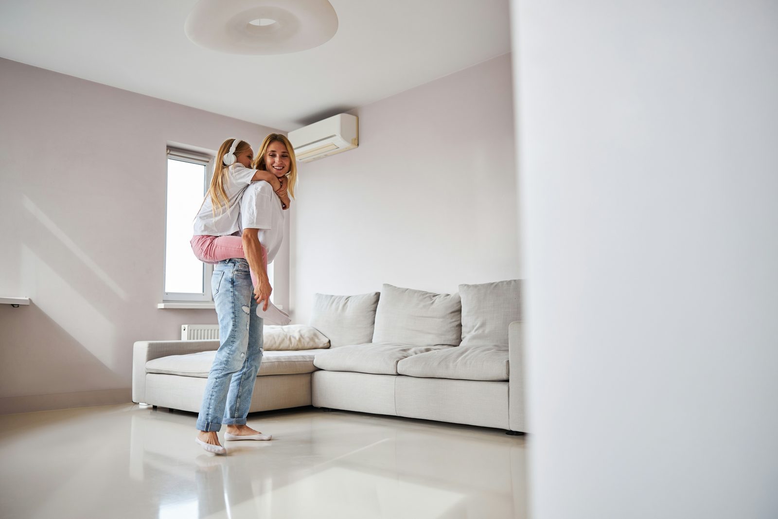 Mother and daughter relaxing at home beneath a wall-mounted ductless mini-split in a Nanaimo living room
